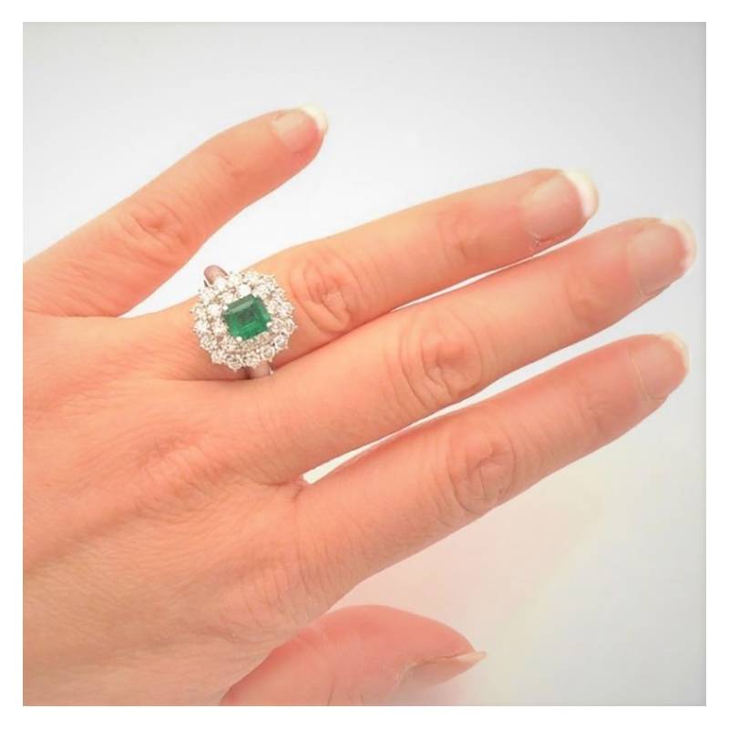 modelo con anillo de compromiso de esmeralda en mano