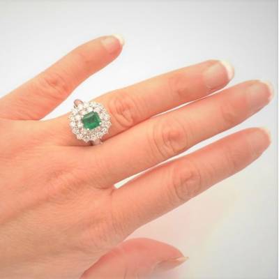 modelo con anillo de compromiso de esmeralda en mano