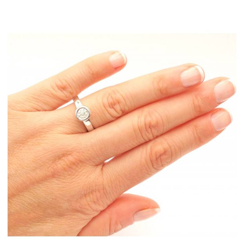 anillo diamante en chatón en mano
