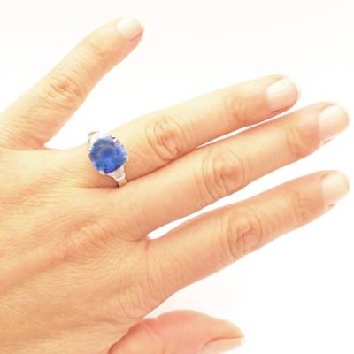 anillo de oro con zafiro azul terciopelo y diamantes en alta joyería para mujer - modelo en mano