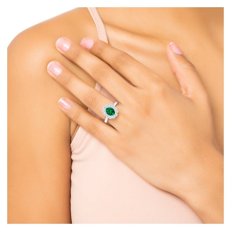 anillos con esmeraldas y diamantes en dedo de modelo