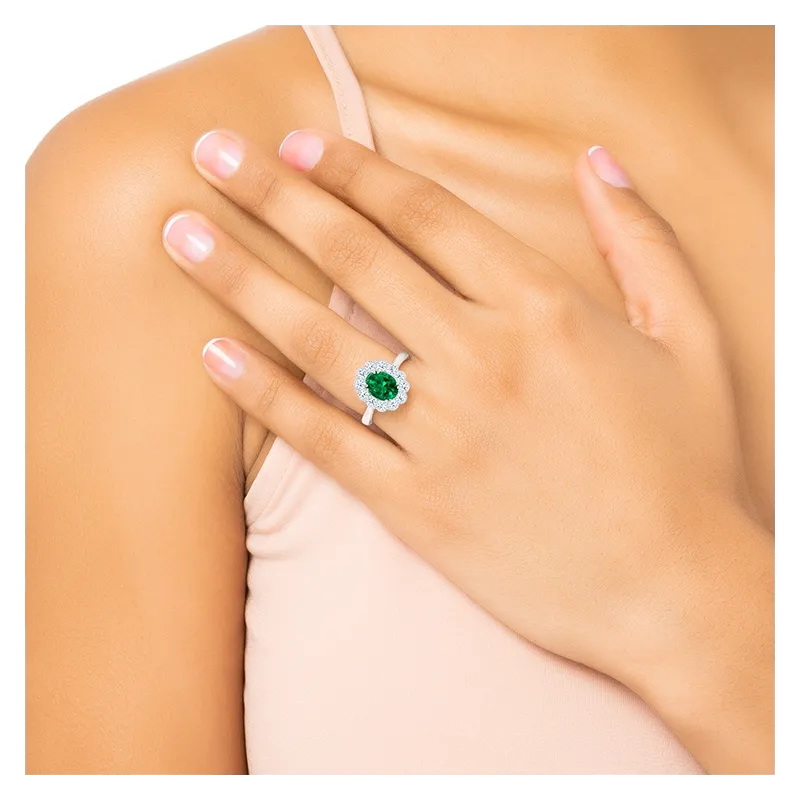 Perspectiva de anillo de esmeralda con orla ovalada puesto en mano. Joyería en Madrid