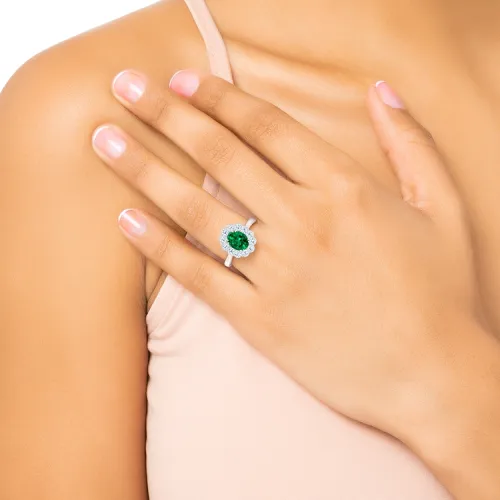 Perspectiva de anillo de esmeralda con orla ovalada puesto en mano. Joyería en Madrid
