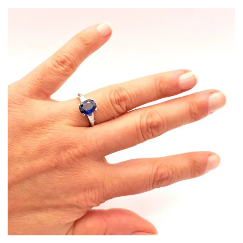 Anillo en mano de oro blanco de 18K con zafiro azul natural de 2.14 cts  y dos diamantes de 0.08 E/F VS