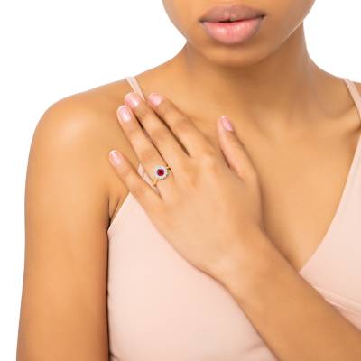 foto de mano de Anillo orla con un rubí redondo de 0,54 cts rodeado de brillantes que aporta luz y brillo