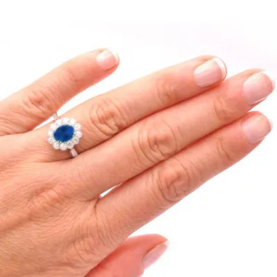 mano con Anillo clásico en oro de 18K con zafiro de 1.83 quilates y orla de diamantes F/G VS
