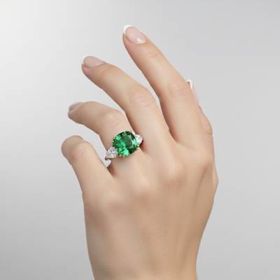 sortija de oro blanco com esmeralda para mujer - en mano de modelo