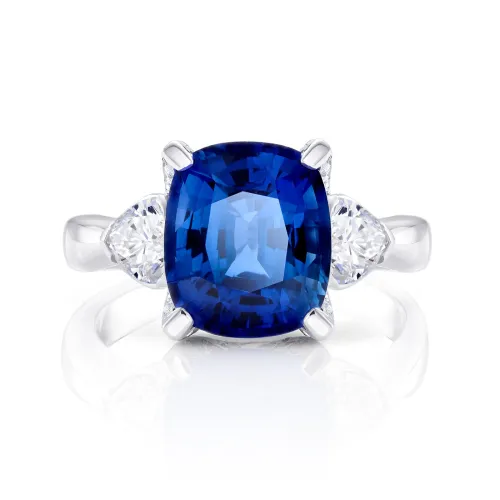 Sortija en oro blanco de 18K con zafiro natural Royal blue talla cushion de 3.84 cts y dos diamantes a los lados de 0.55 cts